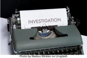 Image of an old fashioned typewriter with paper indicating "Investigation".